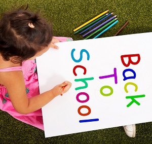 back to school, girl in grass, sign